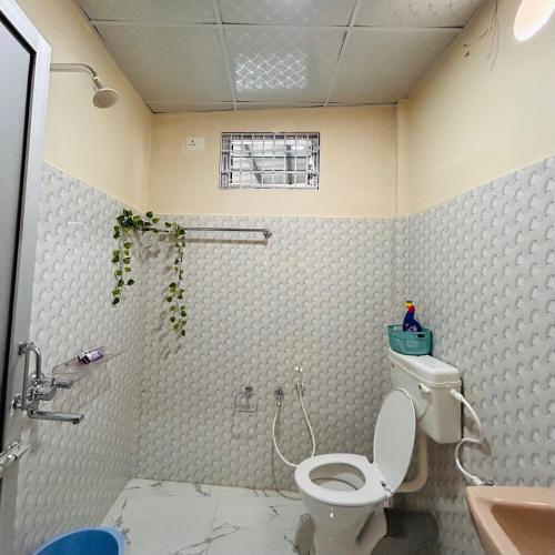 a bathroom with a toilet and a sink at Oak & olive stays in Tezpur