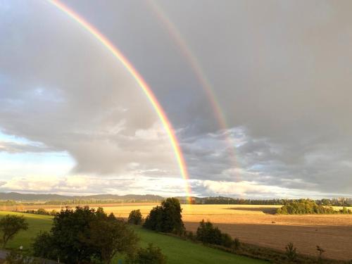 a double rainbow in the sky over a field at Chata Johanka & Sauna in Jevíčko