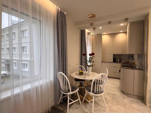 a kitchen and a table and chairs in a room at Centro Apartamentai in Plungė