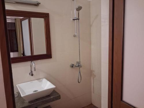 a bathroom with a sink and a mirror and a shower at River Tree Bolgoda in Panadura