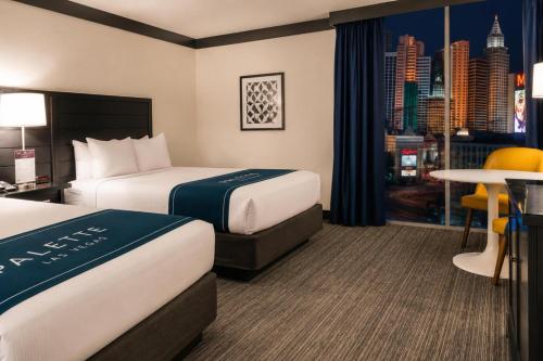 a hotel room with two beds and a table at Palette Las Vegas in Las Vegas