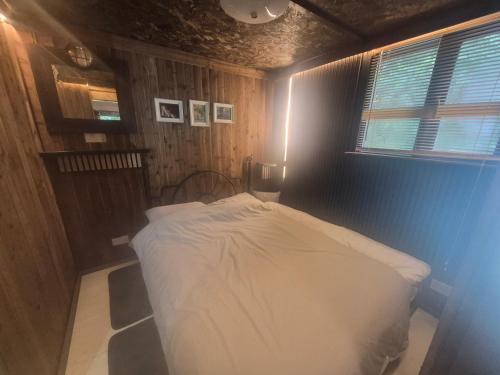 a bedroom with a white bed in a room at Froglets island cabin in Bexley