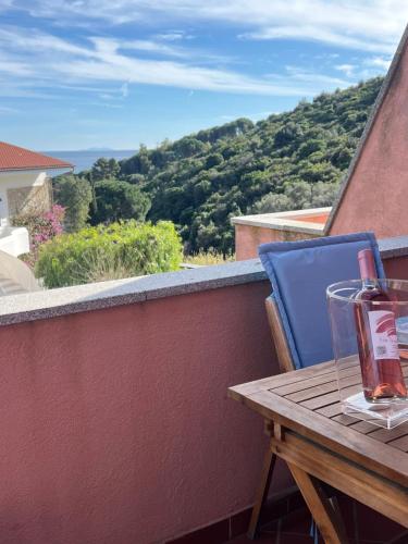 a table on a balcony with a view of a mountain at Appartamento Marisa2 a soli 200mt dal mare e vista mare in Fetovaia