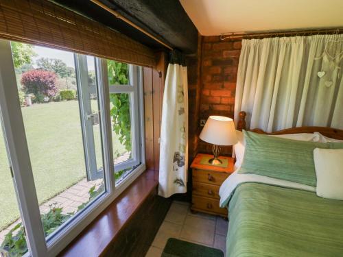 a bedroom with a bed and a large window at Severn Bank Lodge in Shrawley