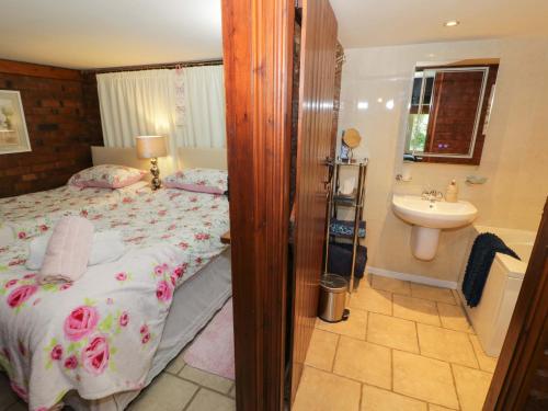 a bedroom with a bed and a sink at Severn Bank Lodge in Shrawley