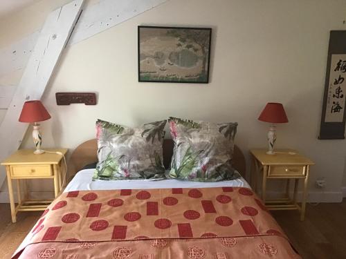 a bedroom with a bed with two lamps and two tables at Cottage Massanet in Grasse