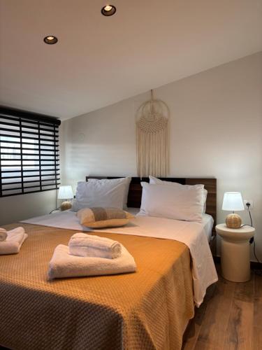 a bedroom with two beds with towels on them at Maya Suites N.Moudania in Nea Moudania