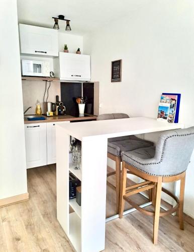 a white kitchen with a desk and a chair at BoHémian Studio in Sète Center in Sète