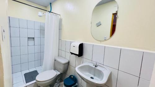 a bathroom with a sink and a toilet and a mirror at Hotel Costa del Sol in Puerto Limón