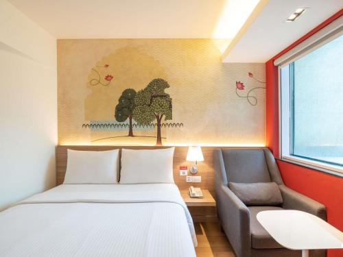 a bedroom with a bed and a chair at ibis Mumbai Airport - An Accor Brand in Mumbai