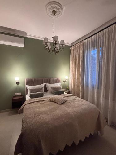 a bedroom with a large bed and a chandelier at Utopia House & Garage in Kavála