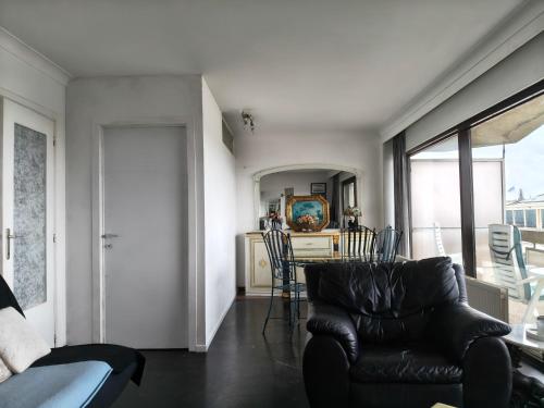 a living room with a couch and a table with chairs at Residentie Aldis met 1 slaapkamer in Ostend