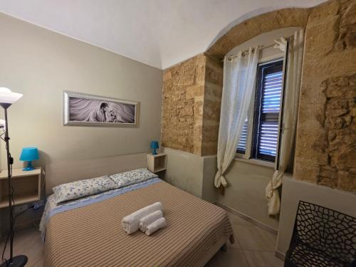 a bedroom with a bed with towels on it at Pasithea House in Marzamemi