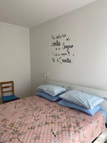 a bedroom with a bed with a quote on the wall at Binario1 Lake View in Lierna