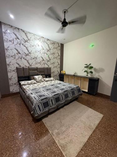 a bedroom with a bed and a ceiling fan at Home stays in Jammu
