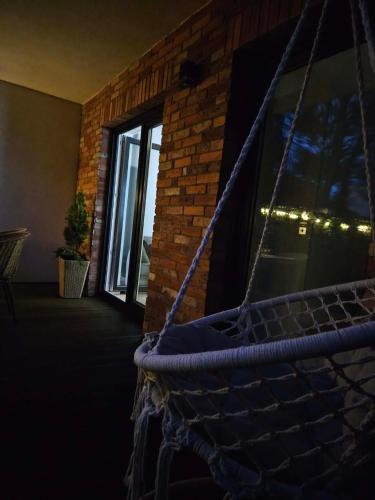a hammock in a room with a window with lights at Apartament Przystań in Łeba