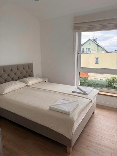 a bed in a bedroom with a large window at White Villa in Darlowko