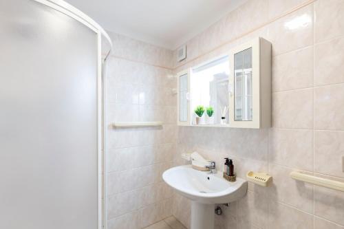 a white bathroom with a sink and a shower at Villa Luna in Simius