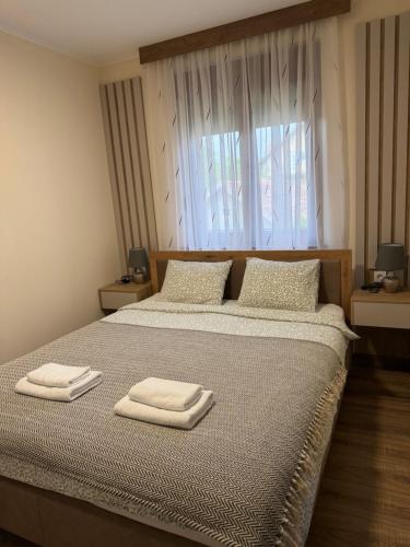 a bedroom with a bed with two towels on it at Casa Due in Novi Sad