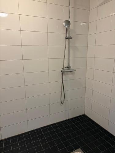 a shower in a white tiled bathroom at Tamminiemi in Luodonmaa