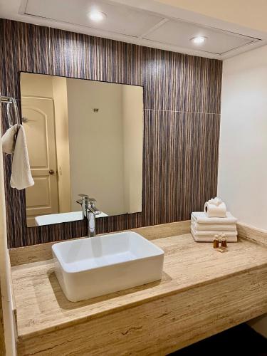 a bathroom with a sink and a large mirror at Ventanas al Paraiso Apartment Cancun in Cancún