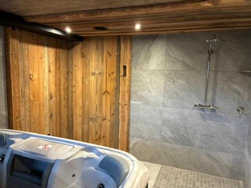 a bathroom with a tub and a stone wall at Nid des aiguillettes in Chevenoz