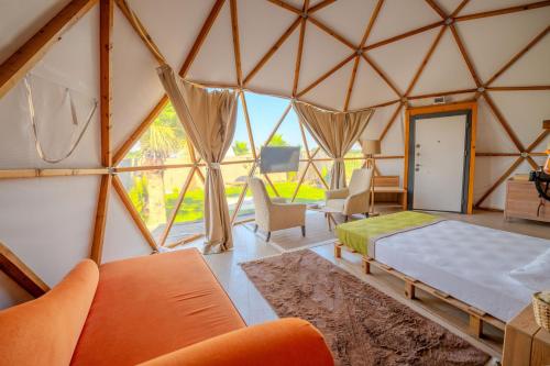 a bedroom in a yurt with a bed and chairs at Belek Glamping House in Çakıllık