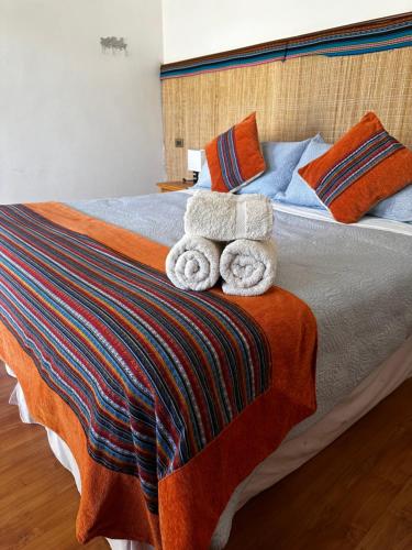 a bed with two towels on top of it at Hotel Pat'ta Hoiri in San Pedro de Atacama