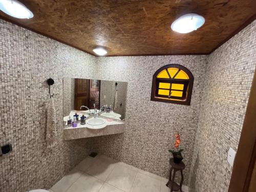 a bathroom with a sink and a mirror at Sítio do vô Hélio - Petropolis in Araras Petropolis