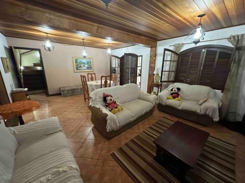a living room with two white couches and a table at Sítio do vô Hélio - Petropolis in Araras Petropolis