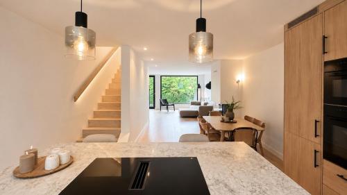a kitchen and living room with a counter and a staircase at The Frogner Park Townhouse with 2 garages in Oslo