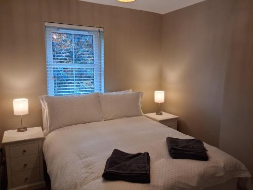 a bedroom with a bed with two towels on it at 56 Woodlands in Clonakilty