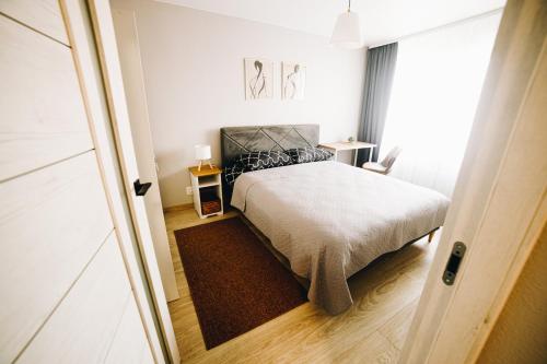 a small bedroom with a bed and a window at LK Darzu Apartment in Rēzekne