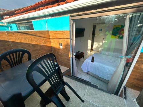 a balcony with a bed and a table and chair at Pousada e Restaurante Morena Raiz in Olinda