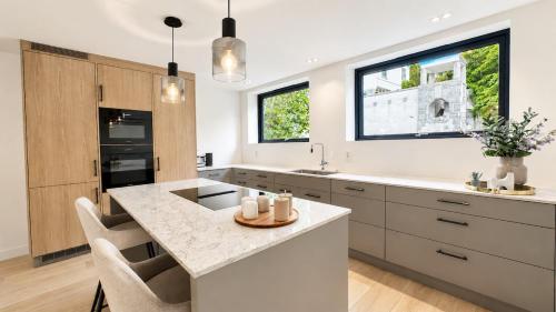 a kitchen with white counters and a large kitchen island at The Frogner Park Townhouse with 2 garages in Oslo