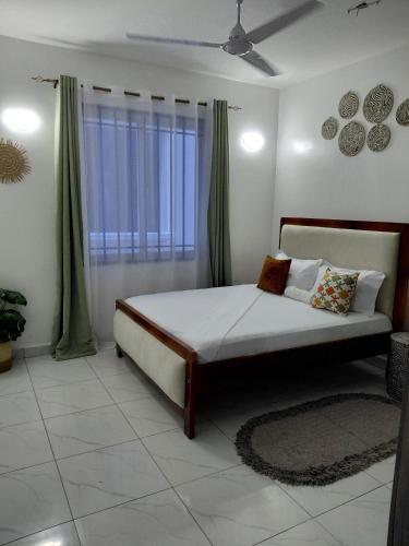 a bedroom with a bed and a window with green curtains at Havy Homes in Bamburi