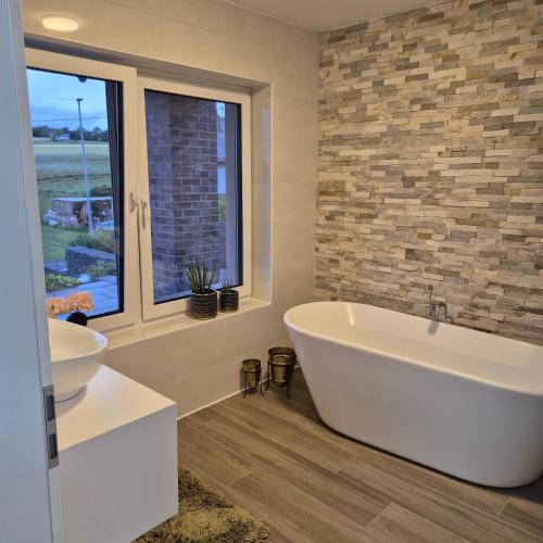 a bathroom with a tub and a sink and a window at Landwiese in Landkern