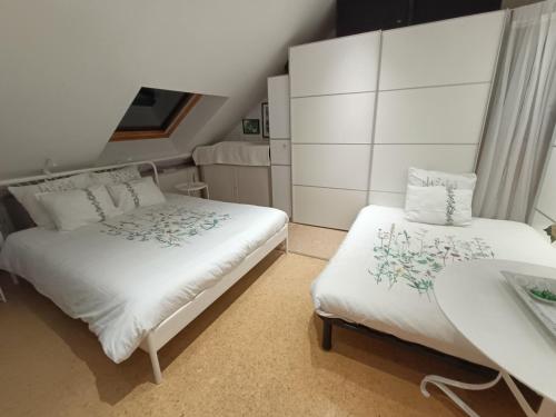 a small bedroom with two beds and a table at Le Jardin des Miroirs in Esneux