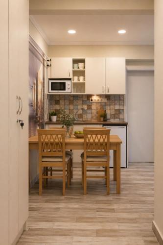 a kitchen with a wooden table and chairs at Evergreen Residence VárLak in Debrecen