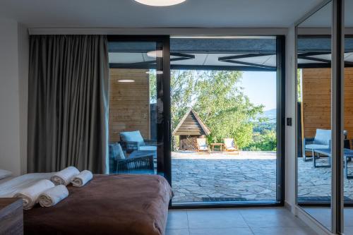 a bedroom with a large glass door leading to a patio at Kosmaj Apartmani Košutica - Marija i Ksenija in Koraćica