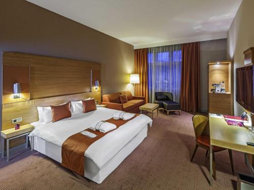 a hotel room with a large bed and a desk at Mercure Ostrava Center in Ostrava