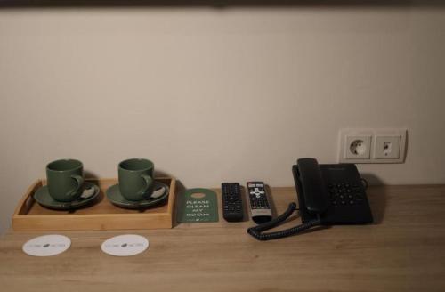 a wooden tray with two coffee cups and a telephone at Aleksberg Club, Dilijan Hotel in Dilijan