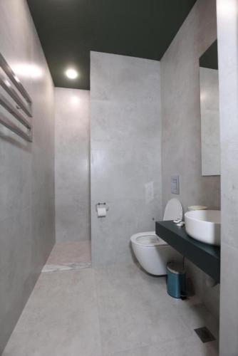 a bathroom with a white toilet and a sink at Aleksberg Club, Dilijan Hotel in Dilijan