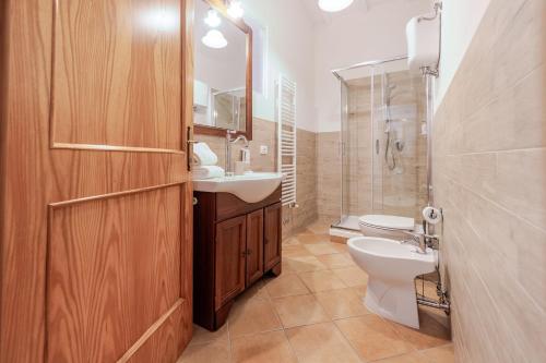 a bathroom with a toilet and a sink and a mirror at La Casa delle Farfalle in Chiusi