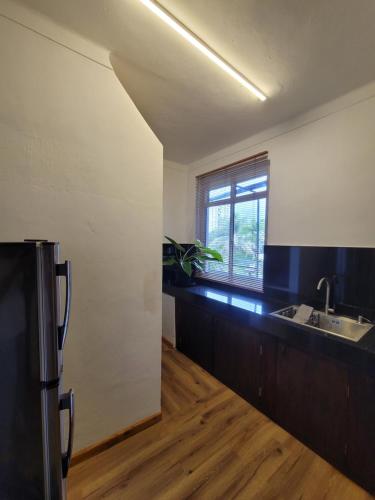 a kitchen with a sink and a window at Bunk 7 in Kandy