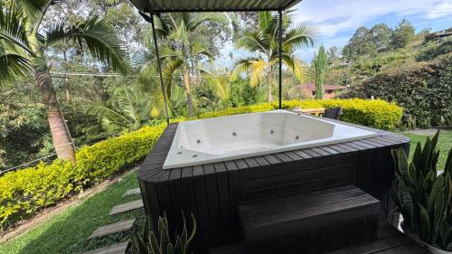 a bath tub sitting in the middle of a garden at Lisboa Hause in Horizonte