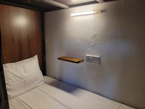 a bedroom with a bed with a light on the wall at Bunk 7 in Kandy
