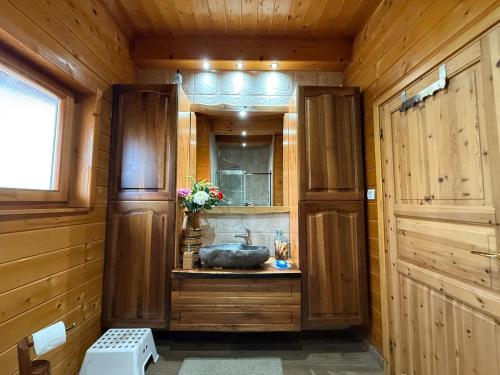 a bathroom with a sink in a wooden room at Violetta Cottage in Užice