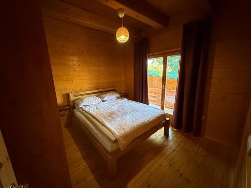a bedroom with a bed in a room with a window at Violetta Cottage in Užice