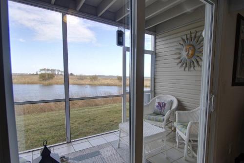a screened in porch with a view of the water at 30399 Pavilion Dr, #1301, Ocean View in Ocean View